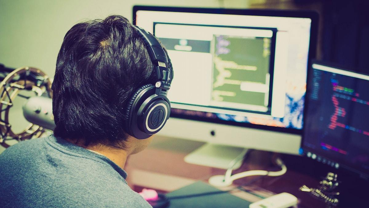 Man studying coding on two screens Man studying coding on two screens