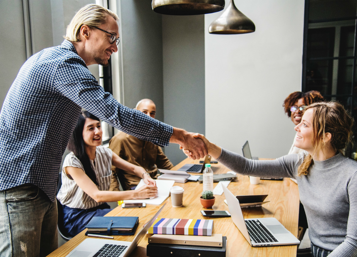 Woman shaking hands with man after negotiating job offer Woman shaking hands with man after negotiating job offer